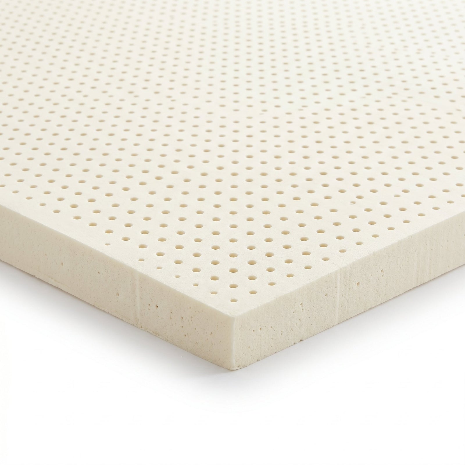 Corner detail of the natural Dunlop latex replacement foam showing the molded pinhole aeration and open-cell texture