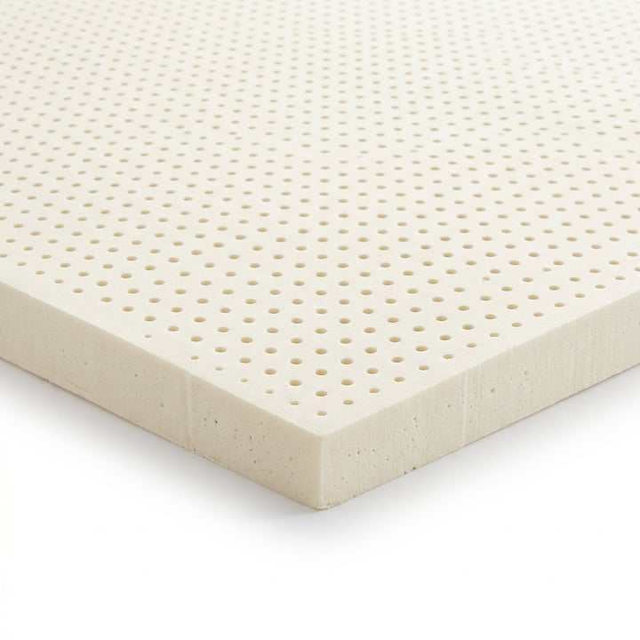 Corner detail of the natural Dunlop latex replacement foam showing the molded pinhole aeration and open-cell texture