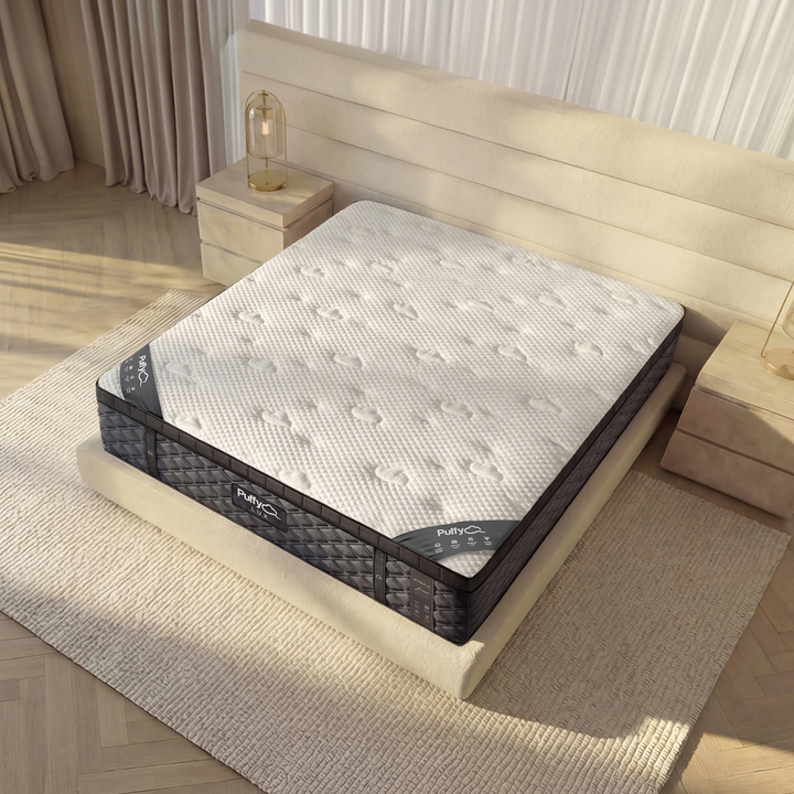 Angled corner view of the Puffy Lux Hybrid highlighting its 12-inch profile and contour-adapt coil base — available at Magic Sleeper, Pottstown, PA.