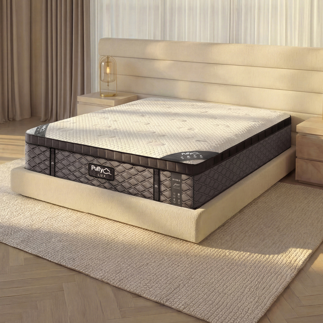 Corner detail of the Puffy Lux Hybrid showcasing its 8-layer design and cooling cloud cover in a warm, styled bedroom scene.