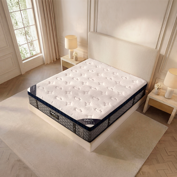 Corner detail of the Puffy Royal Hybrid showcasing its 10-layer design and cool-touch quilted cloud cover in a warm, styled bedroom scene.