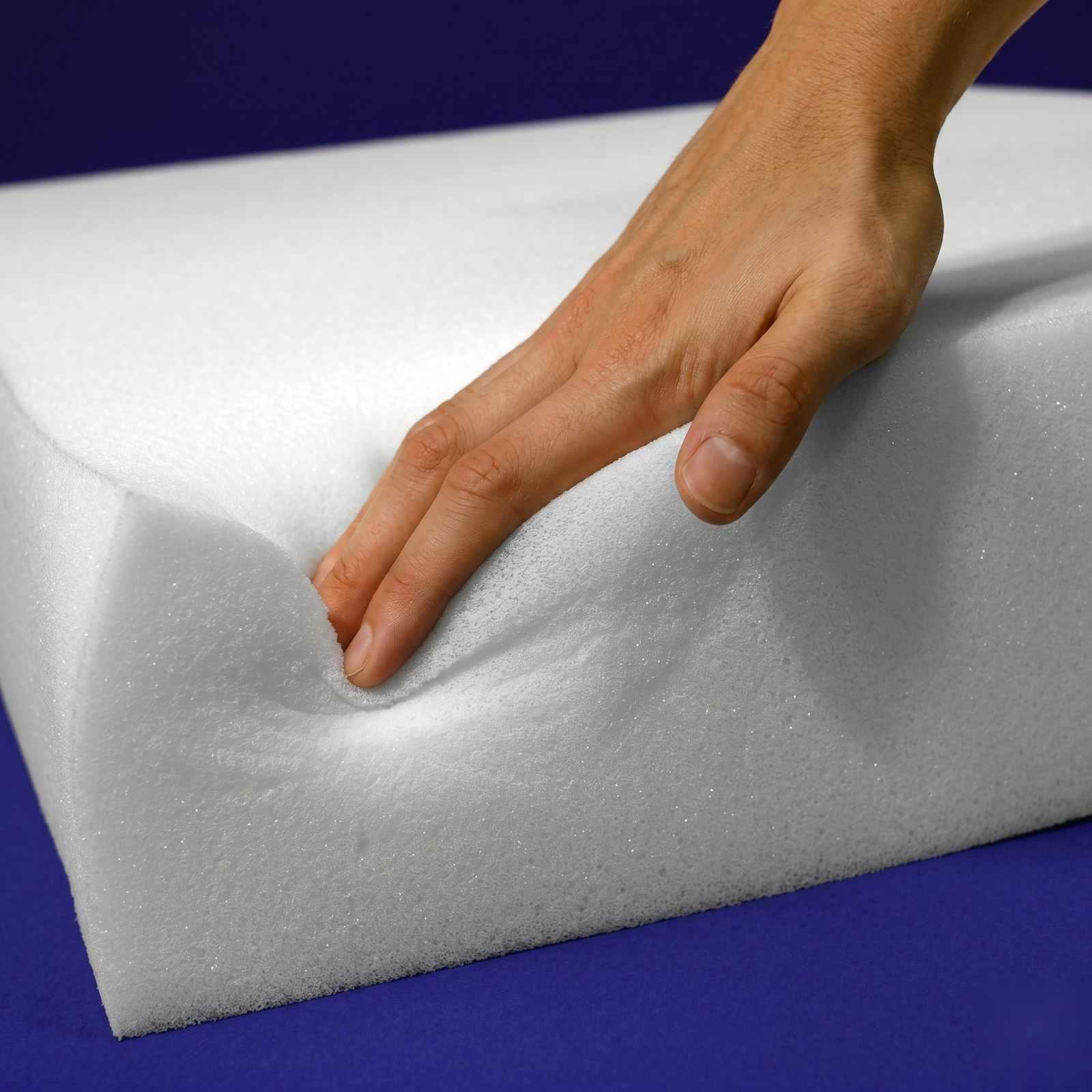 Hand pressing into replacement soft regular foam to show its plush, cushioning feel